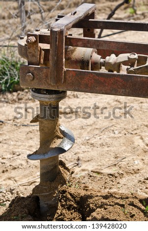 placed in a tractor auger making a hole