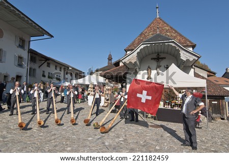 GRUYERE, SWITZELAND, SEPTEMBER 22:Swiss musicians play the alphorn, typical instrument on the main street of the village of Gruyere on September 22, 2011.