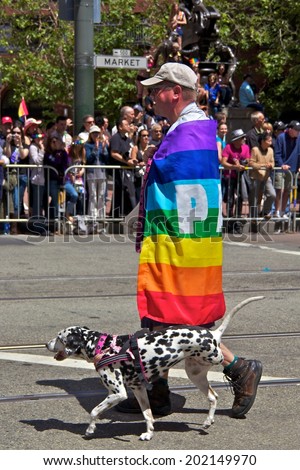 SAN FRANCISCO June 26 2011 - Guy At Gay Pride Wrapped In Rainbow Flag With Three Legged Dog