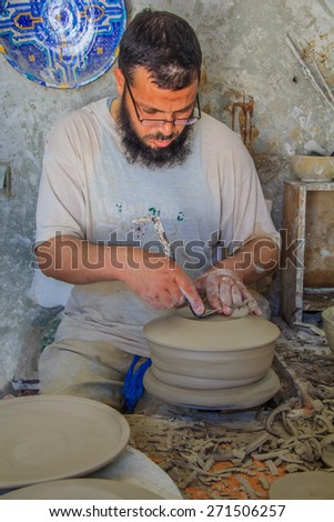 Fes, Morocco - May 11, 2013: Moroccan potter at work in a pottery shop