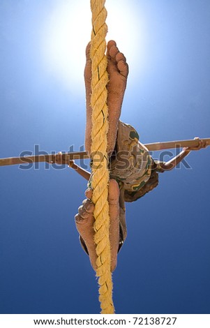 A girl balances herself with 4 meters pole, as she walks along the rope.