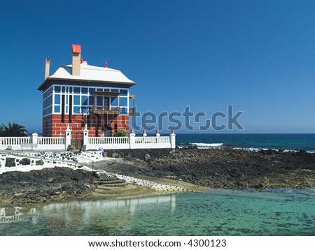 Unusual colorful house overlooking the sea with turquoise sea in foreground