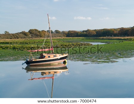 old vintage sailing boat in tidal marshland