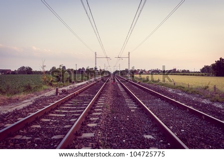 Two rail lines at sunset with corssprocessing  effect