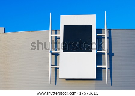 modern building with billboard with blank space for text. Blue sky