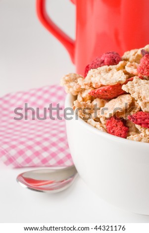 red mug and bowl of cereal and dried red fruits in vertical composition