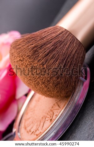 bronze face powder and brush close up in vertical composition