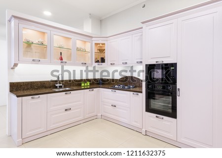Luxury modern light beige kitchen, embedded microwave and electric oven, gas stove, minimalistic clean design