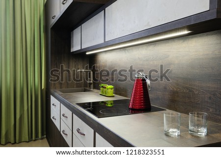 Luxury cozy modern dark brown kitchen interior, induction stove, minimalistic clean design. some drawers are open