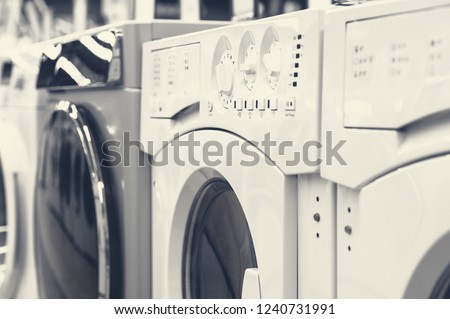 Row of washing mashines in appliance store, toned image