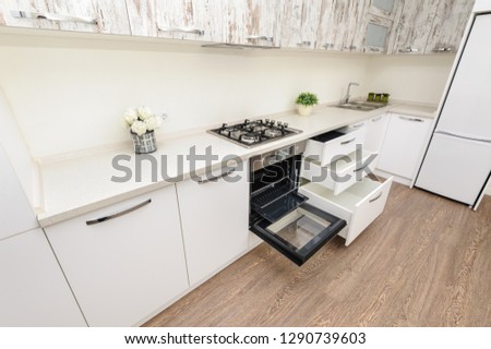 Modern white kitchen, gas stove, electric oven is open