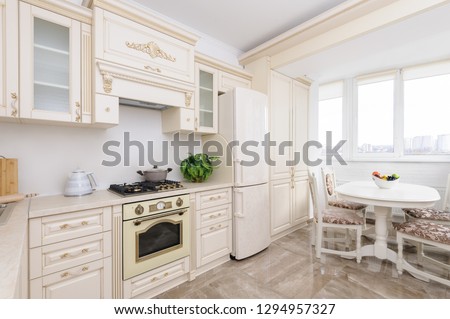 Modern spacioius beige colored luxury kitchen and dining room with panoramic window