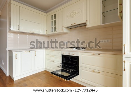 Modern classic spacioius cream colored kitchen, electric oven is open