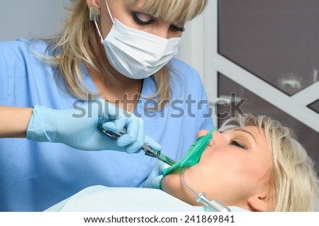 dentist with patient, installation of rubber dam