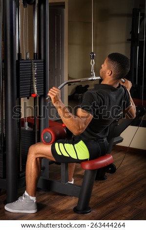 Young man doing lats pull-down workout