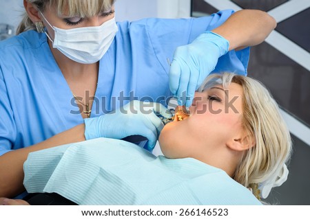 female dentist at work, anaesthesia injection before cavity stopping