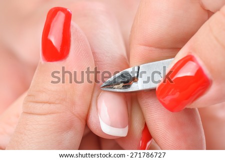 beauty salon, manicure applying, cutting the cuticle with special cutter