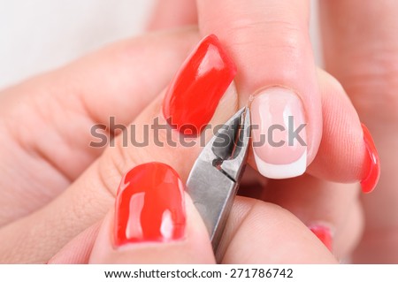 beauty salon, manicure applying, cutting the cuticle with special cutter