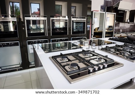 Rows of gas stoves with stainless tray selling in appliance retail store