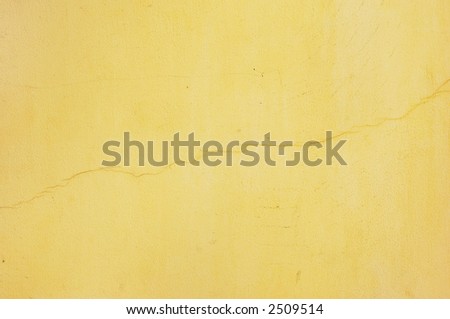yellow unevenly painted stucco with thin diagonal crack