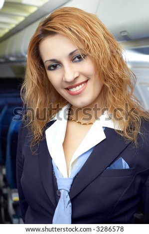 Air hostess (stewardess) in the empty airliner cabin.