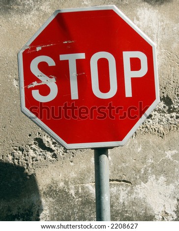 Street sign stop behind old wall surface