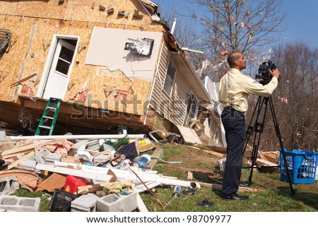 LAPEER COUNTY, MI - MARCH 15: WNEM News reporter James Felton videotapes the aftermath of a home heavily damaged by an F2 tornado that swept through Oregon Twp in Lapeer County, MI on March 15, 2012.