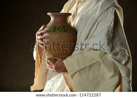 Jesus Holding a jug of water on a dark background