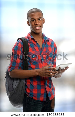 Young black student holding an electronic tablet isolated on a white background