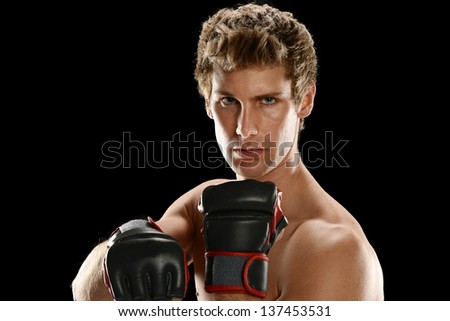 Young Man fighter wearing gloves and isolated on a black background