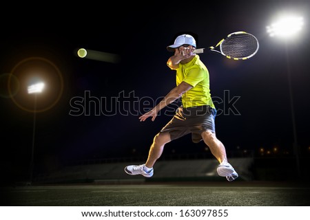 Tennis Player Hitting The Ball At Night