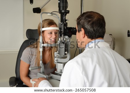 Eye Doctor examining young patient at his office