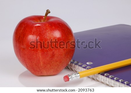 Apple, pen and copybook with white background