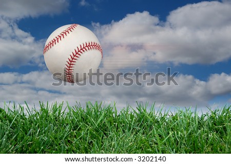 Baseball after impact with grass and clouds