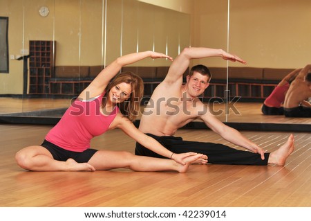 Young couple during a yoga session on a bamboo floor