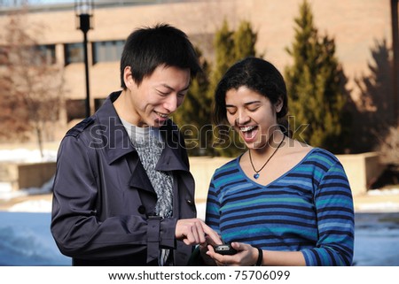 College Students with cell phone in School campus having fun