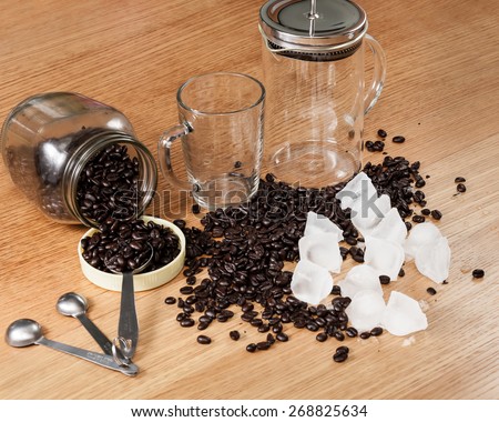 Preparing to make iced coffee at home using whole coffee beans and a French press.