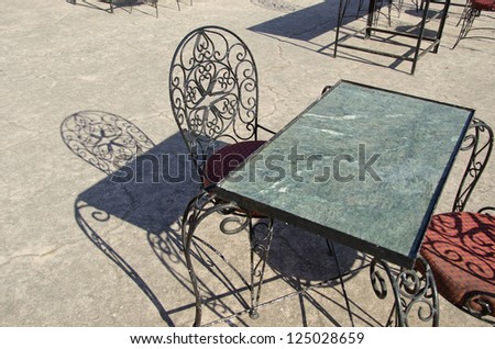 stone table and chair in street coffee-bar and shadows