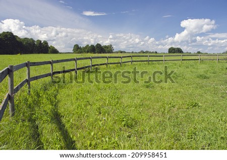 rural summer landscape farmland field with wooden fence