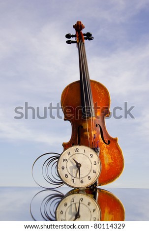 vintage violin and old clock on mirror