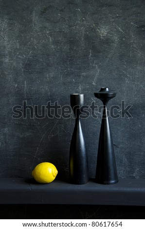 black still-life with one yellow lemon