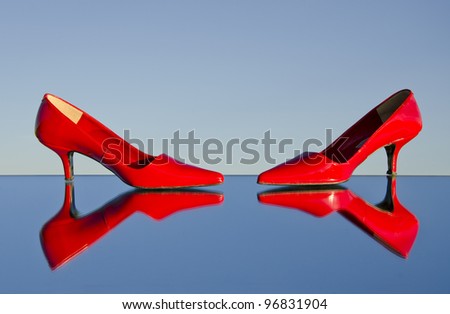 two red stiletto on mirror and blue sky