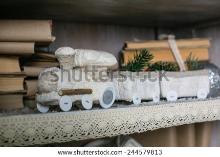 Decorative toy train on a shelf with books, winter