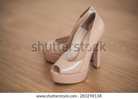 Elegant blonde bride shoes on a wooden floor, wedding accessories