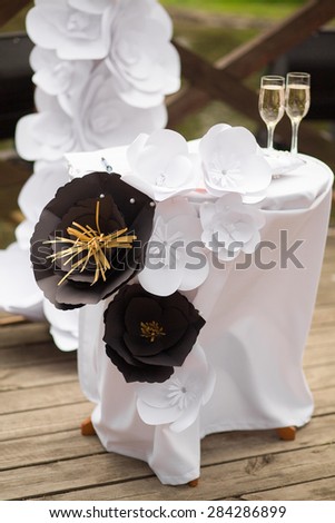 Fancy decorations visiting the wedding ceremony in the form of black and white paper flowers