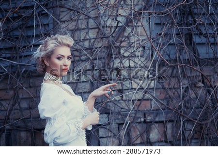 Beautiful blonde in an old white satin dress, a mysterious atmosphere, loneliness, mystery