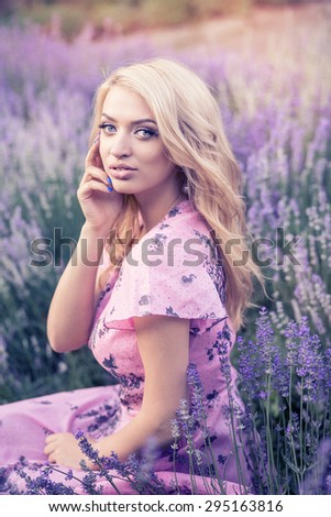 Beautiful girl with blond hair in a simple summer clothes in the middle of lavender fields of Provence