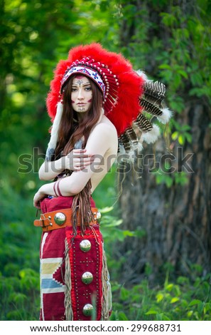 A beautiful Indian woman in a national headdress of red feathers and naked back