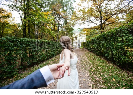 The bride leads the groom in the garden, walk wedding