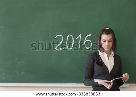 Girl graduate student on a green blackboard, chalk drawn date in 2016, a difficult choice future profession to graduates